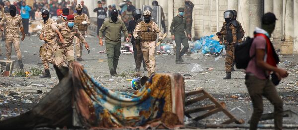 اشتباك عناصر من قوات الأمن العراقية مع المتظاهرين خلال الاحتجاجات المستمرة المناهضة للحكومة في بغداد - سبوتنيك عربي