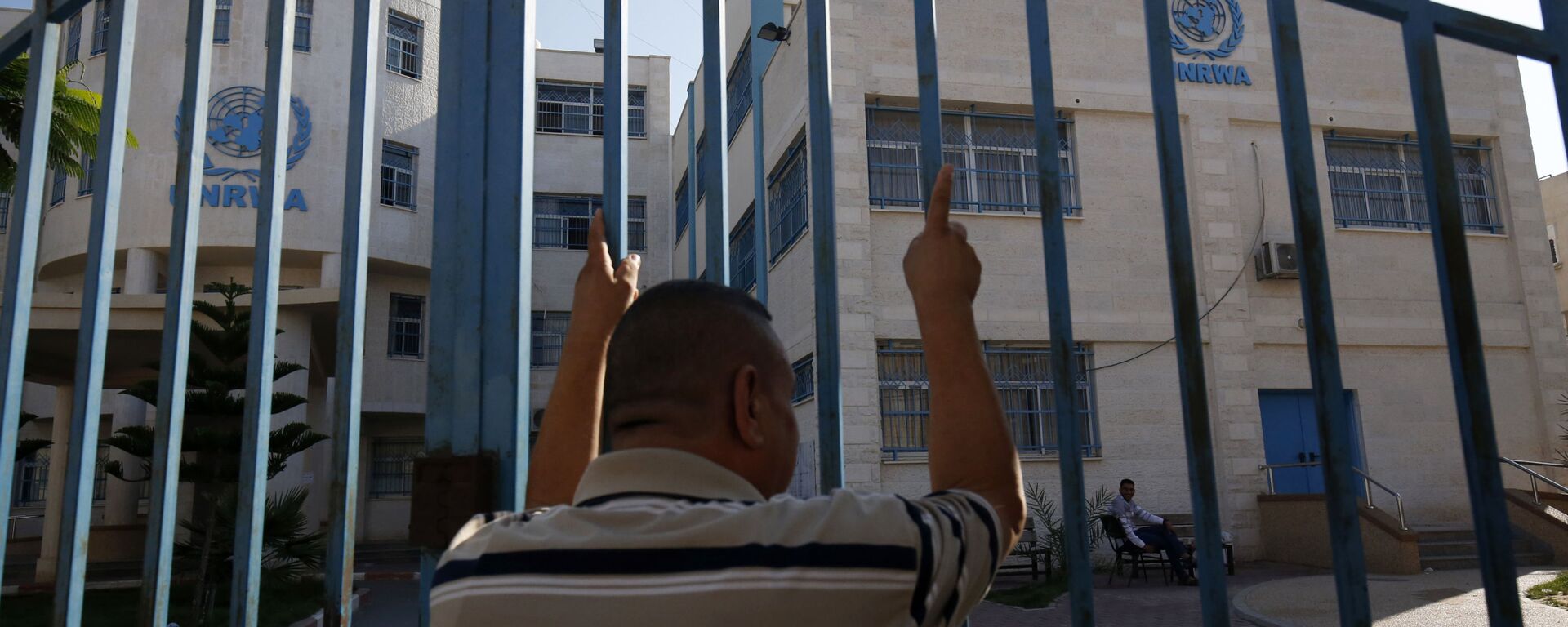 رجل فلسطيني يقف خارج البوابة المغلقة لوكالة غوث وتشغيل اللاجئين الفلسطينيين (الأونروا) - سبوتنيك عربي, 1920, 22.11.2022
