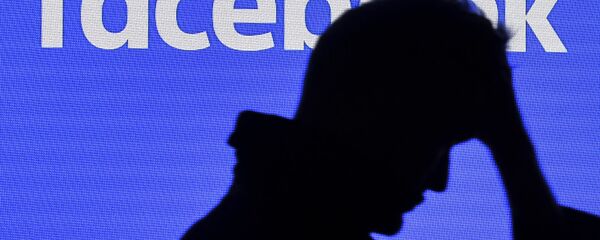 رجل يمر بجانب شاشة فيسبوك رجل يمر بجانب شاشة فيسبوك - سبوتنيك عربي