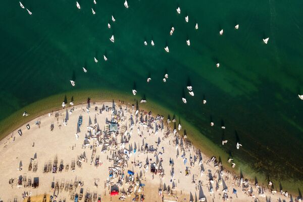 المشاركون في سباق عموم روسيا لركوب القوارب الشراعية في مياه خليج غيلينجيك الروسي - سبوتنيك عربي