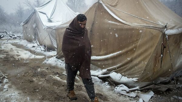 رجل، لاجئ، يسير بين خيام للاجئين بالرغم من بدء البرد وتساقط الثلج في مخيم للاجئين فوجاك، شمال غرب البوسنة، 2 ديسمبر 2019 - سبوتنيك عربي
