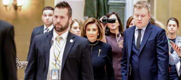 رئيسة مجلس النواب نانسي بيلوسي تعبر قاعة ستاتوري قبل التصويت في مجلس النواب الأمريكي على توجيه الاتهام ضد الرئيس الأمريكي دونالد ترامب في الكابيتول هيل في واشنطن  - سبوتنيك عربي