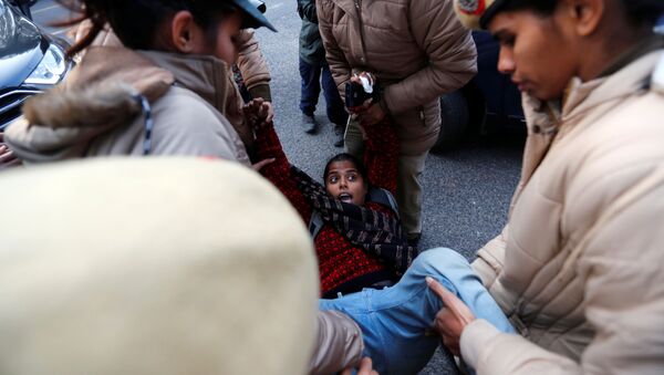 اعتقال متظاهرة من قبل الشرطة خارج ولاية آسام بهوان أثناء احتجاجات على قانون الجنسية الجديد، في نيودلهي، الهند، 23 ديسمبر / كانون الأول 2019. - سبوتنيك عربي