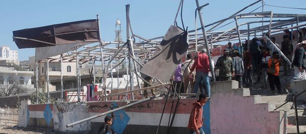 أشخاص يتجمعون في موقع انفجار استهدف عرضًا للتخرج العسكري في مدينة الضالع - سبوتنيك عربي