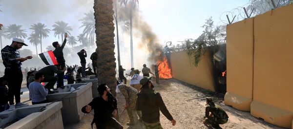 متظاهرون يحرقون سور السفارة الأمريكية في العراق - سبوتنيك عربي