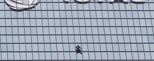 الرجل العنكبوت الفرنسي، ألان روبير، يتسلق برج توتال، في العاصمة الفرنسية باريس، تضامنا مع عمال محتجين على إصلاح نظام معاشات التقاعد، 13 يناير/ كانون الثاني 2020 - سبوتنيك عربي