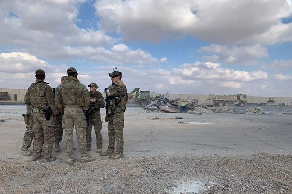 جنود أمريكيون يقفون بينما تقوم الجرافات بإزالة الأنقاض والحطام في قاعدة عين الأسد الجوية في الأنبار في العراق  - سبوتنيك عربي