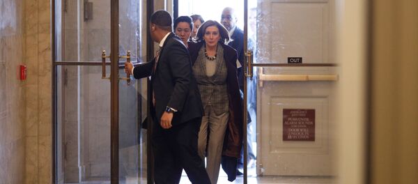 رئيسة مجلس النواب الأمريكي نانسي بيلوسي مع طاقم عملها وهي تسير إلى مكتبها في مبنى الكابيتول الأمريكي في واشنطن - سبوتنيك عربي