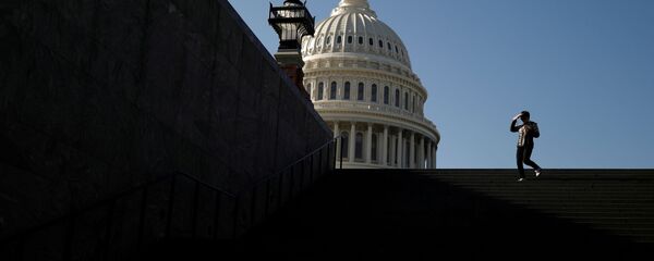 زائر يسير خارج مبنى الكابيتول الأمريكي قبل تصويت متوقع في مجلس النواب على محاكمة ترامب بهدف عزله في واشنطن - سبوتنيك عربي