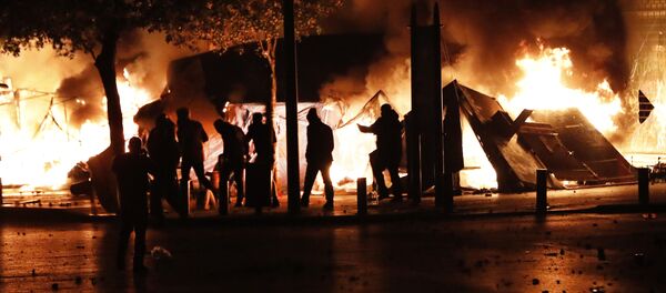 رجال مدنيون يُعتقد أنهم الوحدة الخاصة لحرس البرلمان يمرون بجانب الخيام المشتعلة للمتظاهرين المناهضين للحكومة خلال الاحتجاجات المستمرة ضد النخب السياسية التي حكمت البلاد في بيروت في لبنان  - سبوتنيك عربي