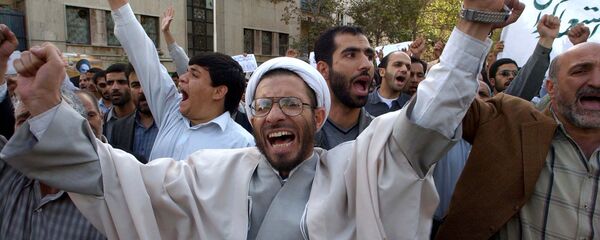 رجل دين إيراني يردد شعارات أثناء احتجاج يندد بتعهد إيران بفتح برنامجها النووي أمام عمليات التفتيش غير المقيدة وتعليق تخصيب اليورانيوم بعد صلاة الجمعة في طهران الجمعة 31 أكتوبر 2003 - سبوتنيك عربي