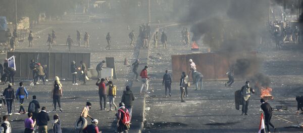 متظاهرون مناهضون للحكومة يشعلون النار ويغلقون الشوارع بينما تستخدم قوات الأمن الغاز المسيل للدموع في وسط بغداد في العراق - سبوتنيك عربي