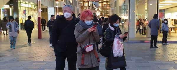 أشخاص يرتدون أقنعة الوجه في بكين لأن الصين تحاول السيطرة على تفشي فيروس كورونا - سبوتنيك عربي