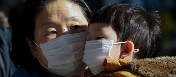 أم وطفلها يرتديان قناع الوجه خوفا من فيروس كرورنا الجديد في كوريا الجنوبية - سبوتنيك عربي