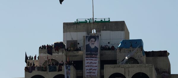 متظاهرون عراقيون يقفون على مبنى شاهق يطلق عليه مبنى المطعم التركي العراقي خلال الاحتجاجات المستمرة المناهضة للحكومة في بغداد - سبوتنيك عربي