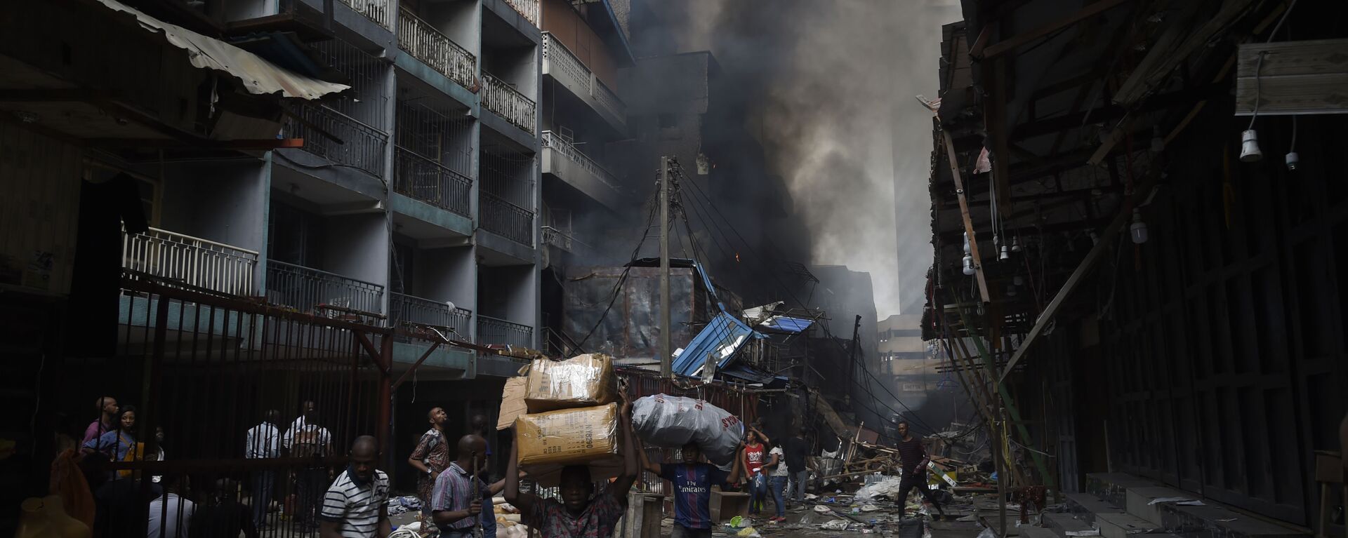 أهالي حي سوق بالوغون في لاغوس يحملون أغراضهم بعد أن تم اطفاء الحريق في المنطقة، نيجيريا 29 يناير 2020 - سبوتنيك عربي, 1920, 08.12.2021