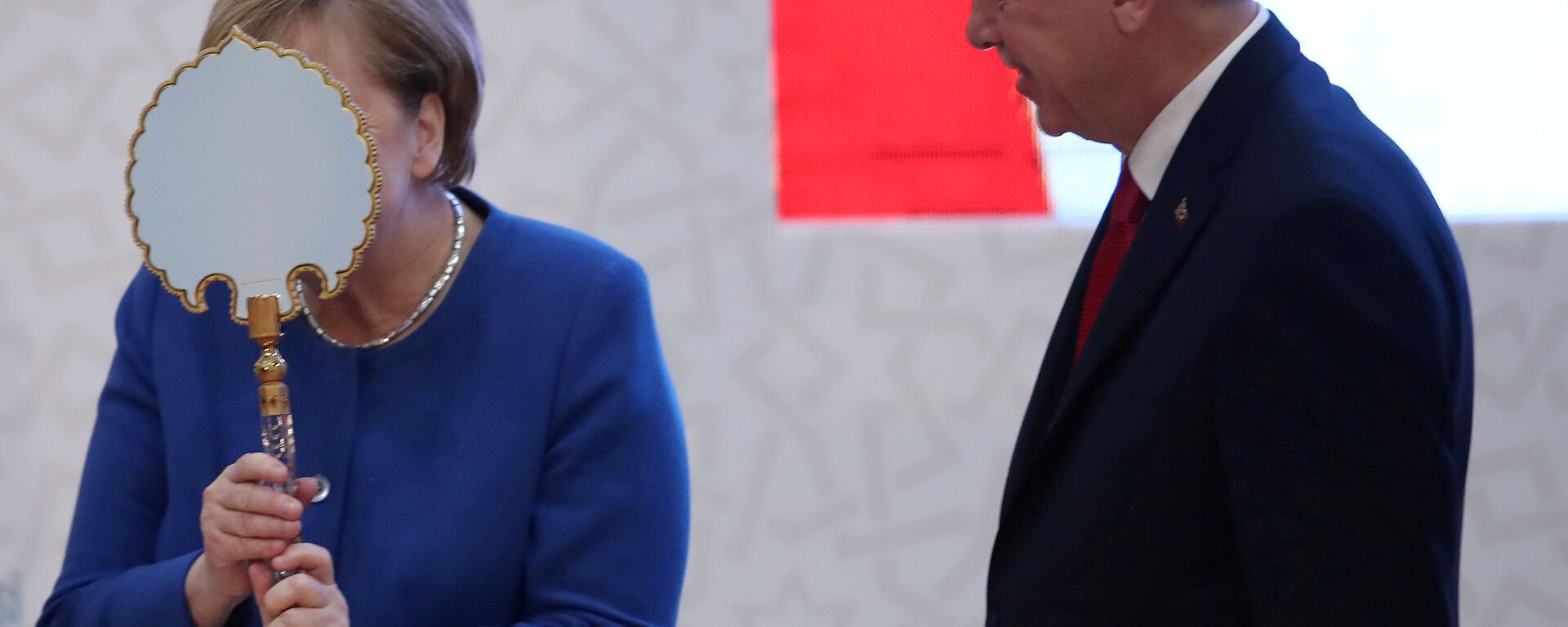 المستشارة الألمانية أنغيلا ميركل تعبر عن سعادتها بالهدية التي قدمها لها الرئيس التركي رجب طيب أردوغان خلال مراسم افتتاح المباني الجديدة للجامعة التركية – الألمانية في إسطنبول، 24 يناير 2020 - سبوتنيك عربي, 1920, 16.10.2021