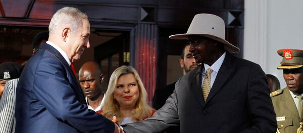 رئيس الوزراء الإسرائيلي بنيامين نتنياهو يصافح الرئيس الأوغندي يوويري موسيفيني في عنتيبي بينما تنظر زوجته سارة نتنياهو - سبوتنيك عربي