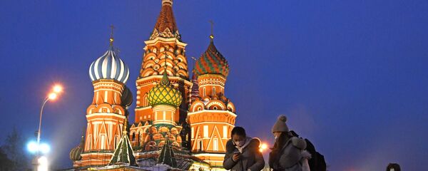 سياح يرتدون أقنعة واقية بعد تأكيد حالات الإصابة بفيروس كورونا في روسيا، يلتقطون صورا في موسكو، 1 فبراير 2020 - سبوتنيك عربي