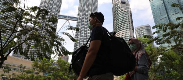 سياح يرتدون أقنعة واقية بعد تأكيد حالات الإصابة بفيروس كورونا في ماليزيا، 31 يناير 2020 - سبوتنيك عربي