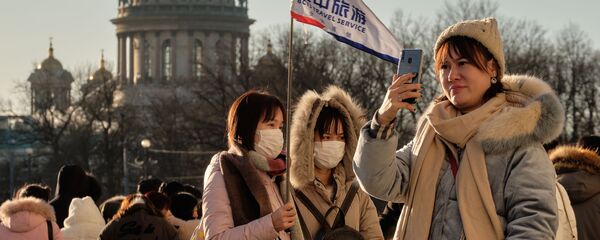 سياح صينيون يرتدون أقنعة واقية، يلتقطون صورا في سان بطرسبورغ، 23 يناير 2020 - سبوتنيك عربي