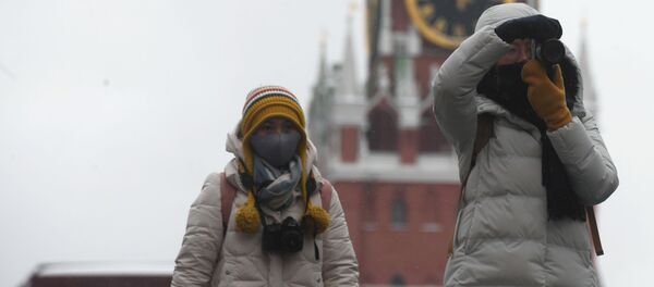أشخاص يرتدون أقنعة واقية بعد تأكيد حالات الإصابة بفيروس كورونا في روسيا، يلتقطون صورا في موسكو، 28 يناير 2020 - سبوتنيك عربي