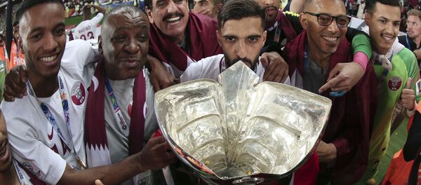 اللاعبون وأعضاء الفريق القطري يحتفلون بالكأس بعد فوزهم في المباراة النهائية لكأس الاتحاد الآسيوي لكرة القدم بين اليابان وقطر في مدينة زايد الرياضية في أبو ظبي في الإمارات 2019 - سبوتنيك عربي