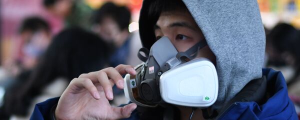 شاب يرتدي قناعا واقيا في محطة القطارات في مدينة بكين الصينية، 24 يناير 2020 - سبوتنيك عربي