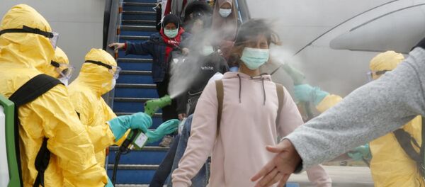 أطباء يقوم برش مطهر طبي على مواطنين إندونيسيين بعد وصولهم من مدينة ووهان الصينية، 2 فبراير 2020 - سبوتنيك عربي