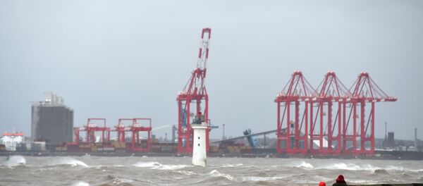 ناس يمشون على طول الكورنيش بينما تتأرجح الأمواج في مصب نهر ميرسي، مقابل ميناء ليفربول للحاويات، شمال غرب إنجلترا، تزامنا مع اجتياح عاضقة سيارة للبلاد، 9 فبراير/ شباط 2020 - سبوتنيك عربي