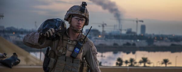 أحد أفراد مشاة البحرية الأمريكية مع الكتيبة الثانية المارينز السابع الذي يعد جزءًا من قوة الرد السريع يحمل كيسًا من الرمل أثناء تعزيز مجمع السفارة الأمريكية في بغداد في العراق - سبوتنيك عربي