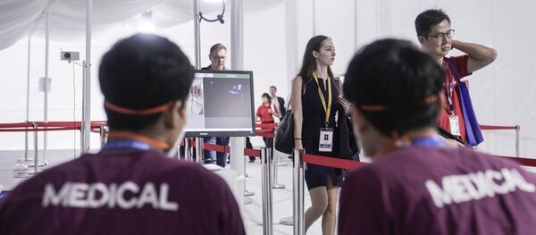 يمر الزوار عبر ماسحة ضوئية حرارية عند وصولهم إلى معرض سنغافورة للطيران - سبوتنيك عربي