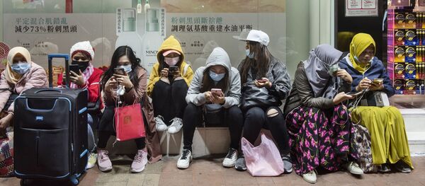 نساء يرتدين أقنعة واقية في أحد شوارع هونغ كونغ، كورونا - سبوتنيك عربي
