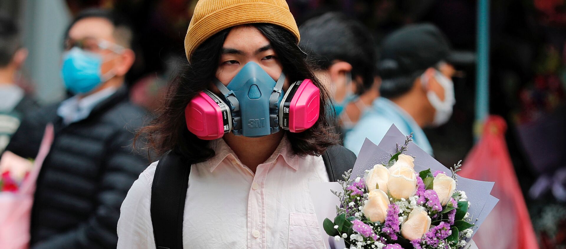 رجل يرتدي قناعا واقيا ويحمل باقة زهور بمناسبة يوم فالنتاين (عيد الحب) في هونغ كونغ، الصين 14 فبراير 2020 - سبوتنيك عربي, 1920, 12.02.2021