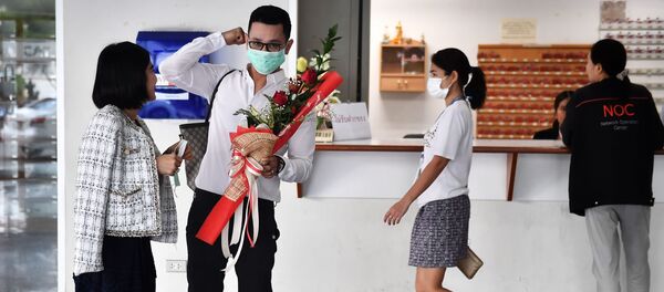 زوجان يرتديان أقنعة واقية في مركز لتسجيل الحالات المدنية في يوم فالنتاين (عيد الحب) في بانكوك، تايلاند 14 فبراير 2020 - سبوتنيك عربي