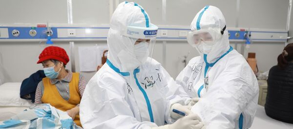 طاقم طبي يعتني بمريض صاب بفيروس كورونا في إقليم هوبي الصيني - سبوتنيك عربي