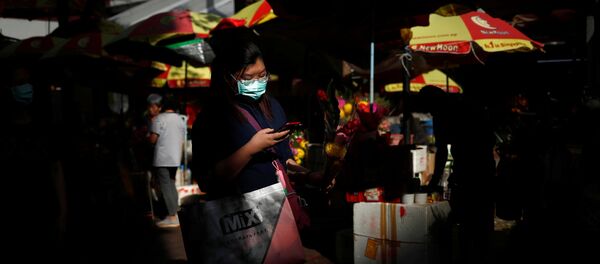 سيدة ترتدي كمامة واقية من فيروس كورونا المستجد وتحمل في يدها باقة زهور خارج معبد كوان إيم هود تشو في سنغافورة - سبوتنيك عربي