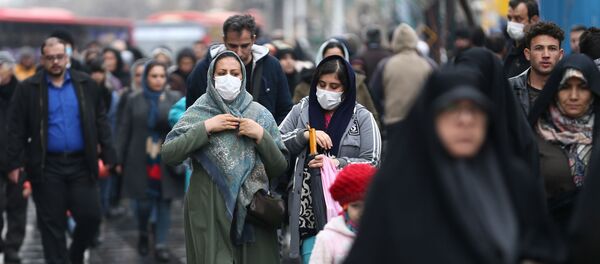 مواطنات إيرانيات يرتدين كمامات واقية من فيروس كورونا خلال سيرهن في أحد شوارع طهران - سبوتنيك عربي