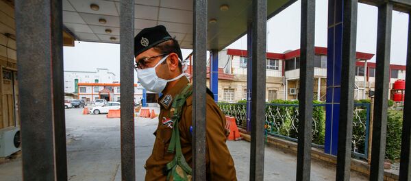 ضابط أمن عراقي يرتدي قناعًا وقائيًا في أحد المستشفيات في أعقاب تفشي فيروس كورونا الجديد في مدينة النجف المقدسة في العراق - سبوتنيك عربي