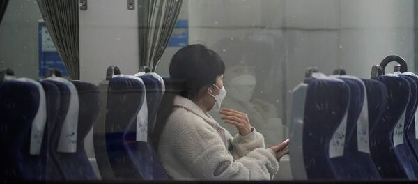 امرأة ترتدي كمامة واقية من فيرووس كورونا تجلس داخل قطار في محطة سكة حديد سيئول فبراير / شباط 2020 - سبوتنيك عربي