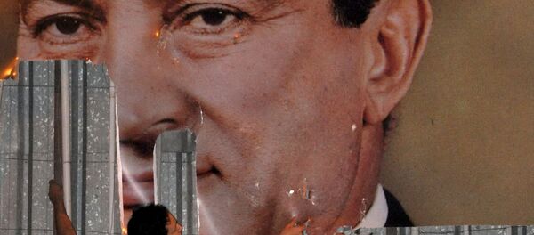 متظاهر مناهض للحكومة يشوه صورة الرئيس المصري حسني مبارك في الإسكندرية في 25 يناير 2011 - سبوتنيك عربي