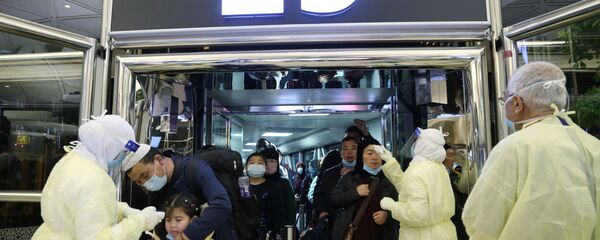 موظفو وزارة الصحة السعودية يقومون بفحص المسافرين القادمين من الصين لدى وصولهم إلى مطار الملك خالد الدولي في الرياض لمنع فيروس كورونا الجديد  - سبوتنيك عربي