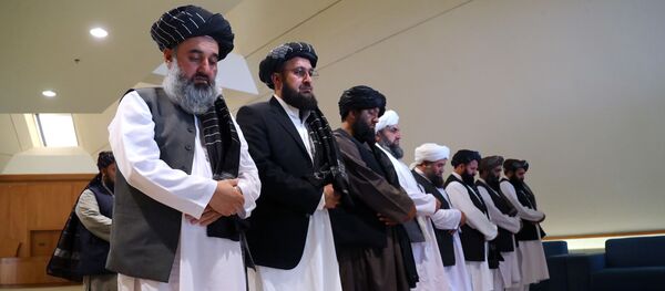 يصلي أعضاء وفد طالبان قبل توقيع الاتفاق بينهم وبين المسؤولين الأمريكيين في الدوحة - سبوتنيك عربي