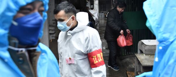 متطوعون يسلمون الأطعمة للمواطنين داخل المنازل في منطقة ووهان الصينية - سبوتنيك عربي