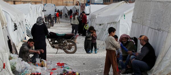 سوريون نازحون داخلياً في معسكر للنازحين في ملعب رياضي حيث توضع الخيام في إدلب - سبوتنيك عربي