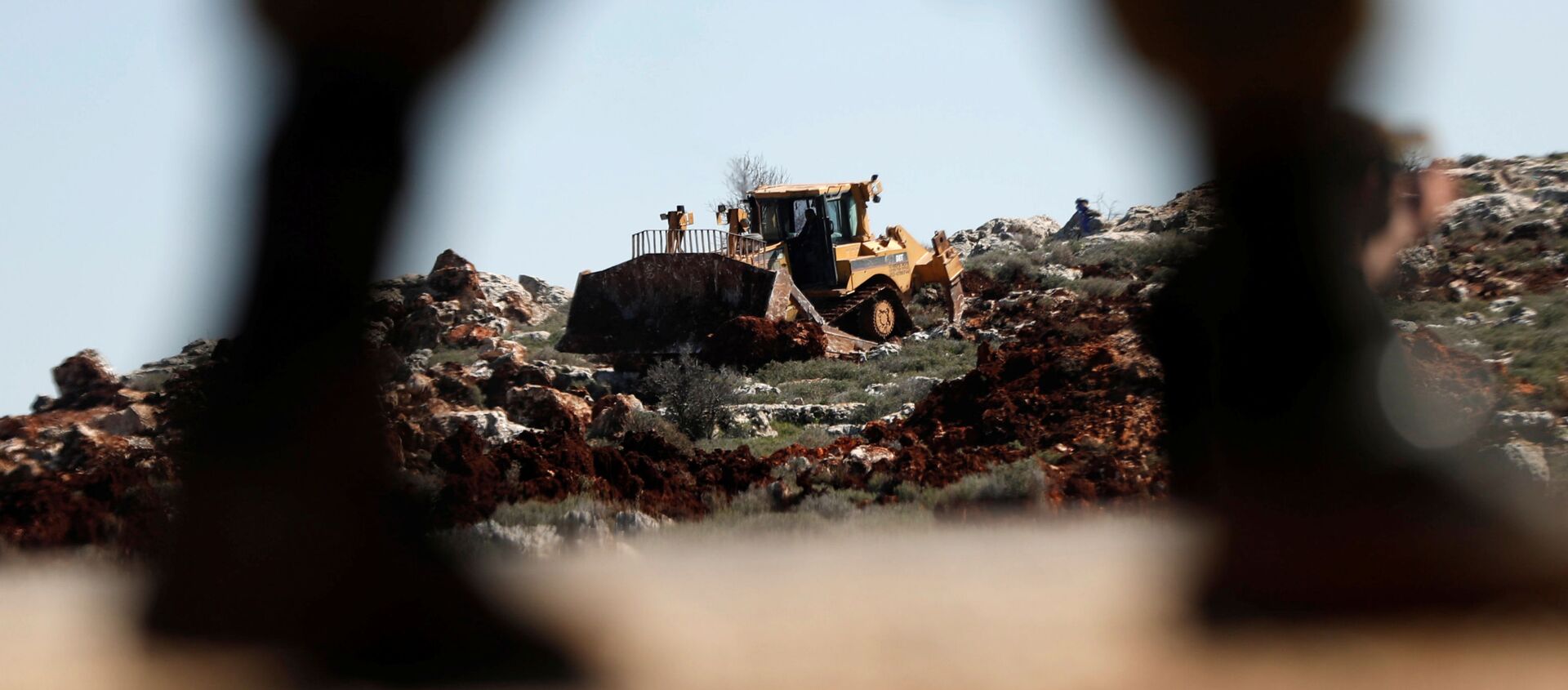 جرافة تحرسها القوات الإسرائيلية تقوم بتجريف الأراضي بالقرب من قرية قصرة الفلسطينية في الضفة الغربية المحتلة  - سبوتنيك عربي, 1920, 28.03.2020