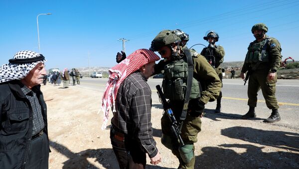 رجل فلسطيني يحتج على الأجهزة الإسرائيلية التي تجرف الأراضي يتجادل مع القوات الإسرائيلية بالقرب من قرية قصرة في الضفة الغربية المحتلة  - سبوتنيك عربي