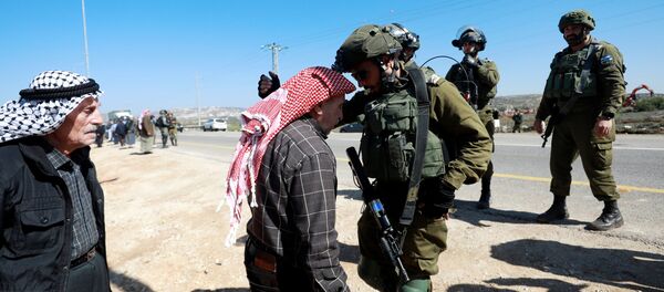 رجل فلسطيني يحتج على الأجهزة الإسرائيلية التي تجرف الأراضي يتجادل مع القوات الإسرائيلية بالقرب من قرية قصرة في الضفة الغربية المحتلة  - سبوتنيك عربي