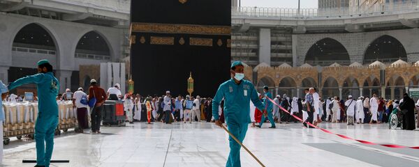 عمال النظافة يرتدون كمامات طبية، أثناء مسحهم للأرض في الكعبة المشرفة في المسجد الحرام في مدينة مكة المكرمة، المملكة العربية السعودية، في أعقاب انتشار فيروس كورونا المستجد، 3 مارس/ آذار 2020 - سبوتنيك عربي