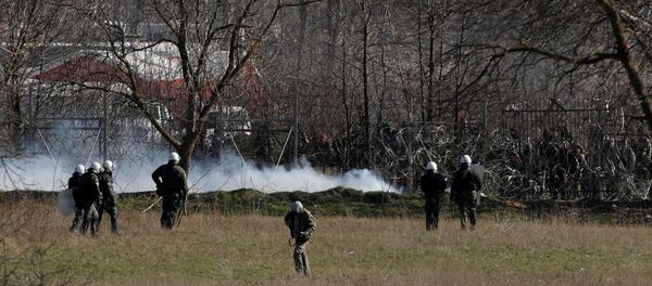 الأمن اليوناني يستخدم خراطيم المياه بينما ينظر المهاجرون بالقرب من معبر بازاركولي الحدودي التركي مع كاستانتس اليونانية بالقرب من أدرنة - سبوتنيك عربي